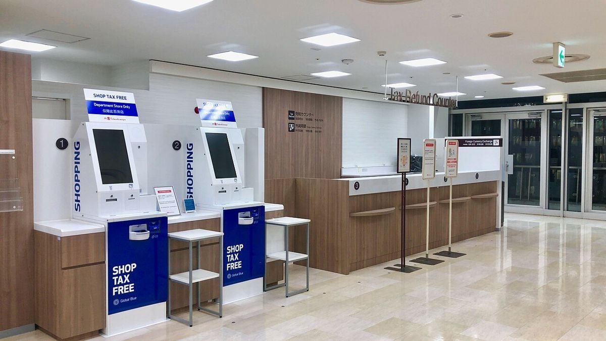 Tax refund counter in a Japanese department store with two self-service tax-free kiosks and a staffed service desk