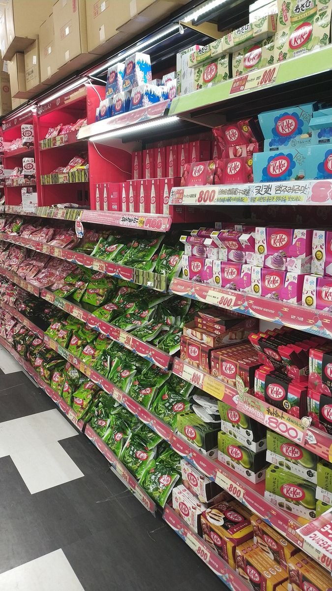 Store shelves stacked with colorful boxes of Japan-only Kit Kat flavors in Osaka