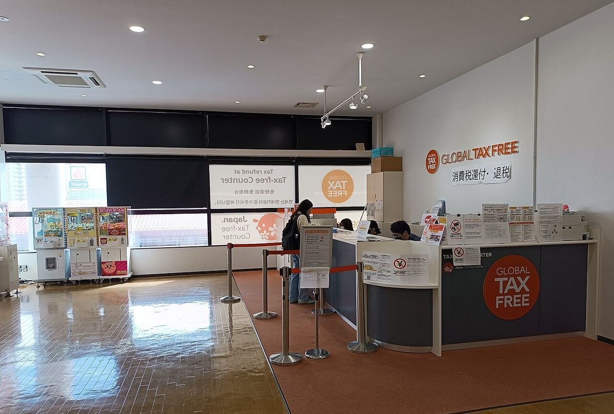 Tax-free service counter with a round TAX FREE sign at an outlet mall in Okinawa