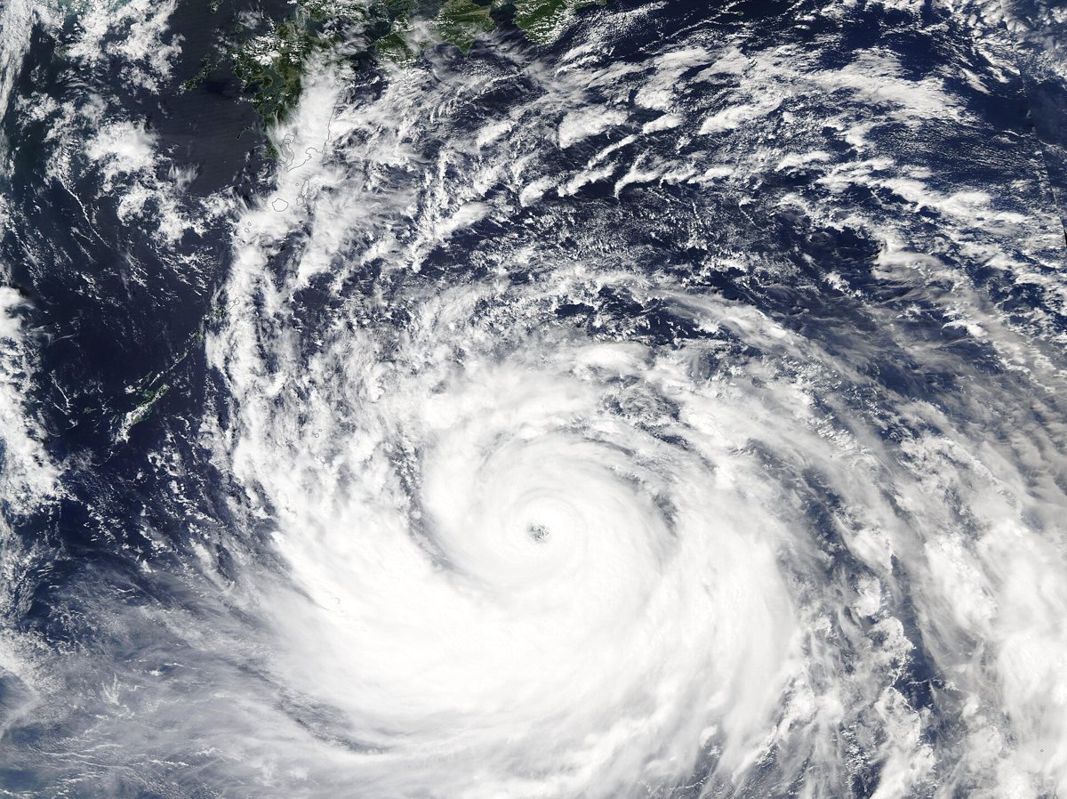 Satellite image of a large typhoon with a clear eye spiralling over the ocean south of Japan