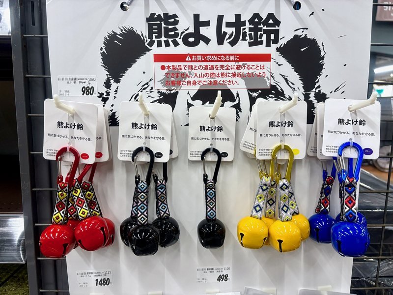Rows of colorful bear bells with carabiners hanging for sale in a Japanese store (item type photo, not the exact product)