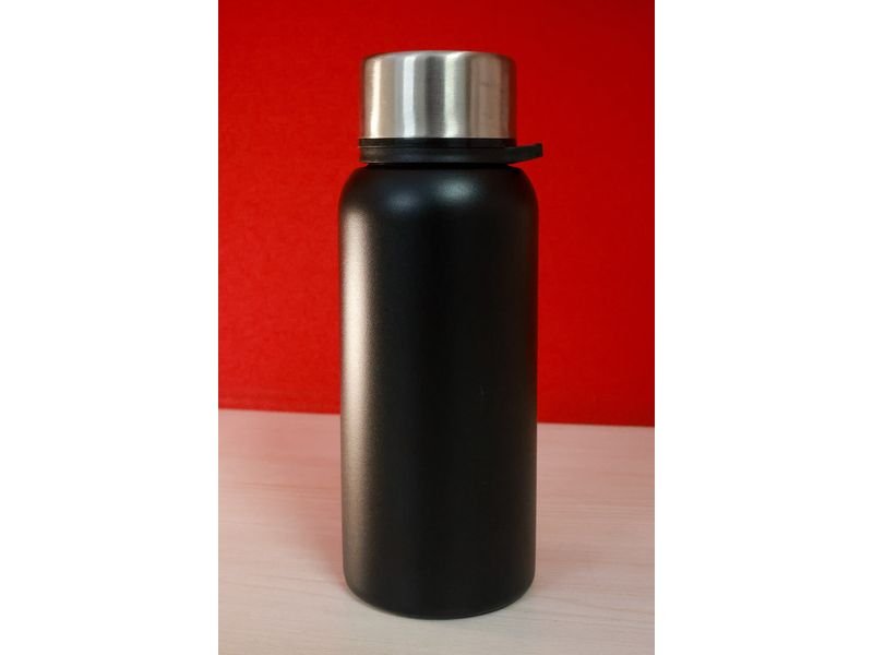 A black stainless steel water bottle with a silver cap on a table (item type photo, not the exact product)