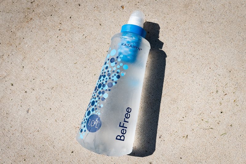 A soft plastic water filter bottle lying on a woven surface (item type photo, not the exact product)